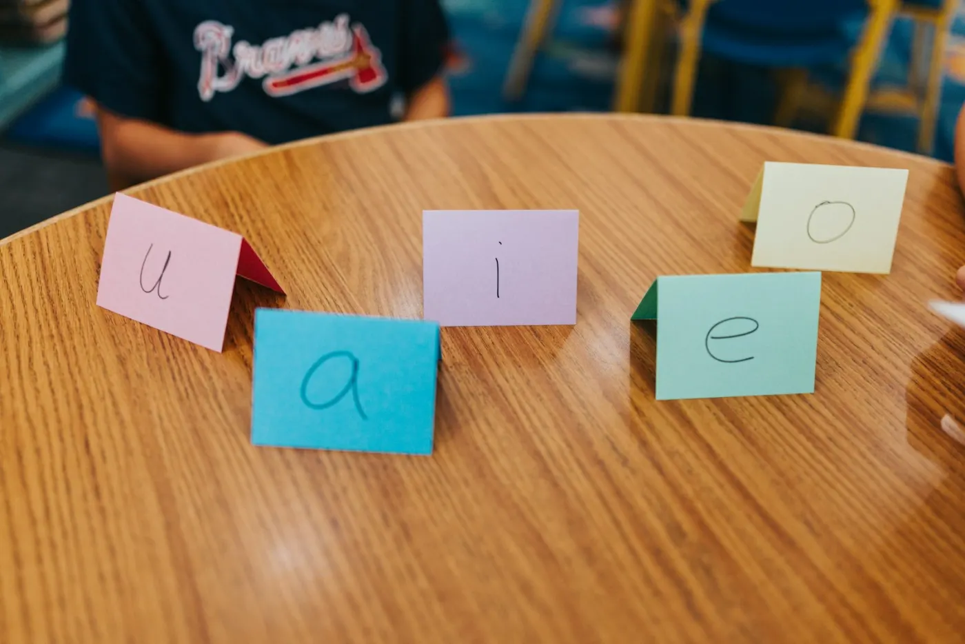 Hand-written index cards standing on a wooden table